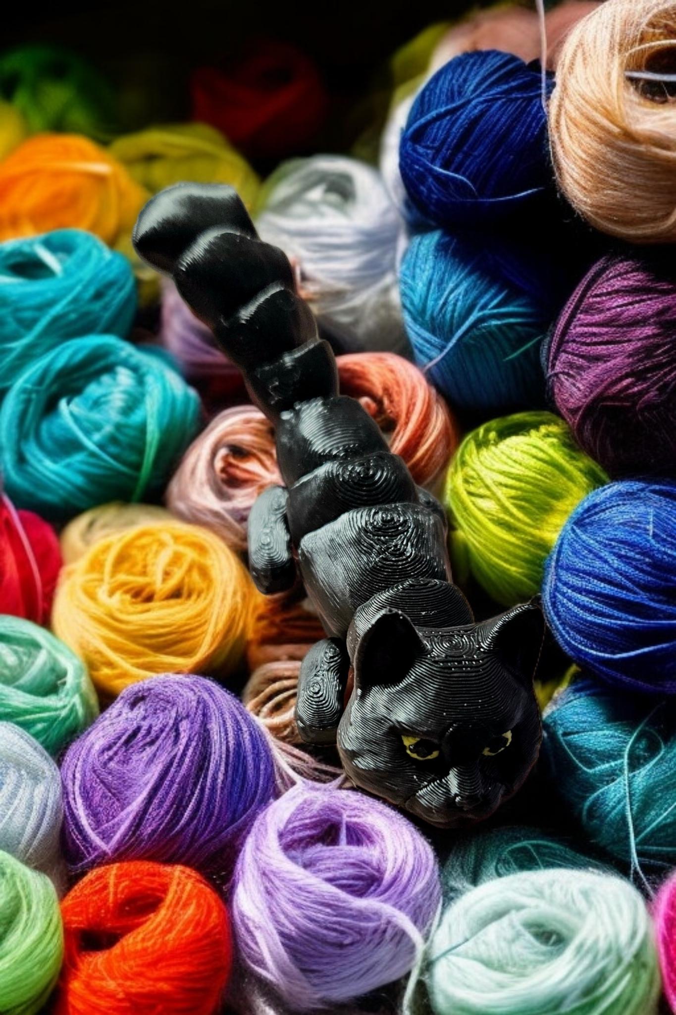 Black 3D printed articulated cat figurine posed among colorful yarn balls on Etsy
