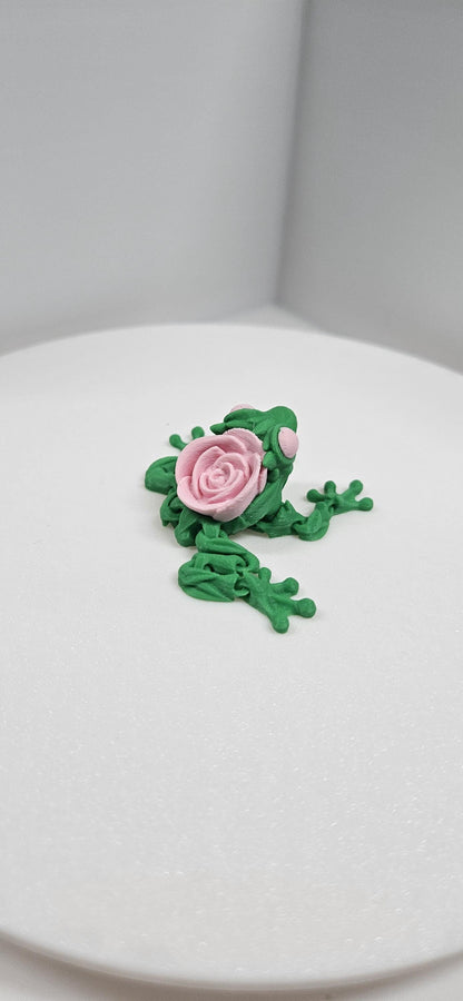 3D printed articulated rose frog figurine with green body and pink rose on back