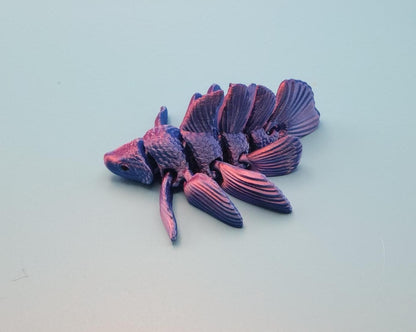 Purple and black 3D printed betta fish toy with detailed fins and textured body on a light background