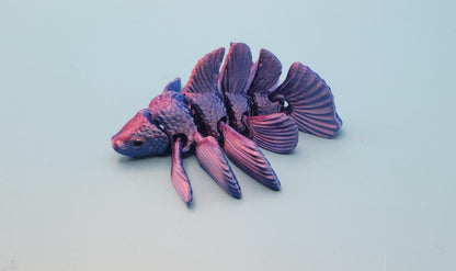 Purple and pink 3D printed betta fish toy with detailed fins on a light blue background
