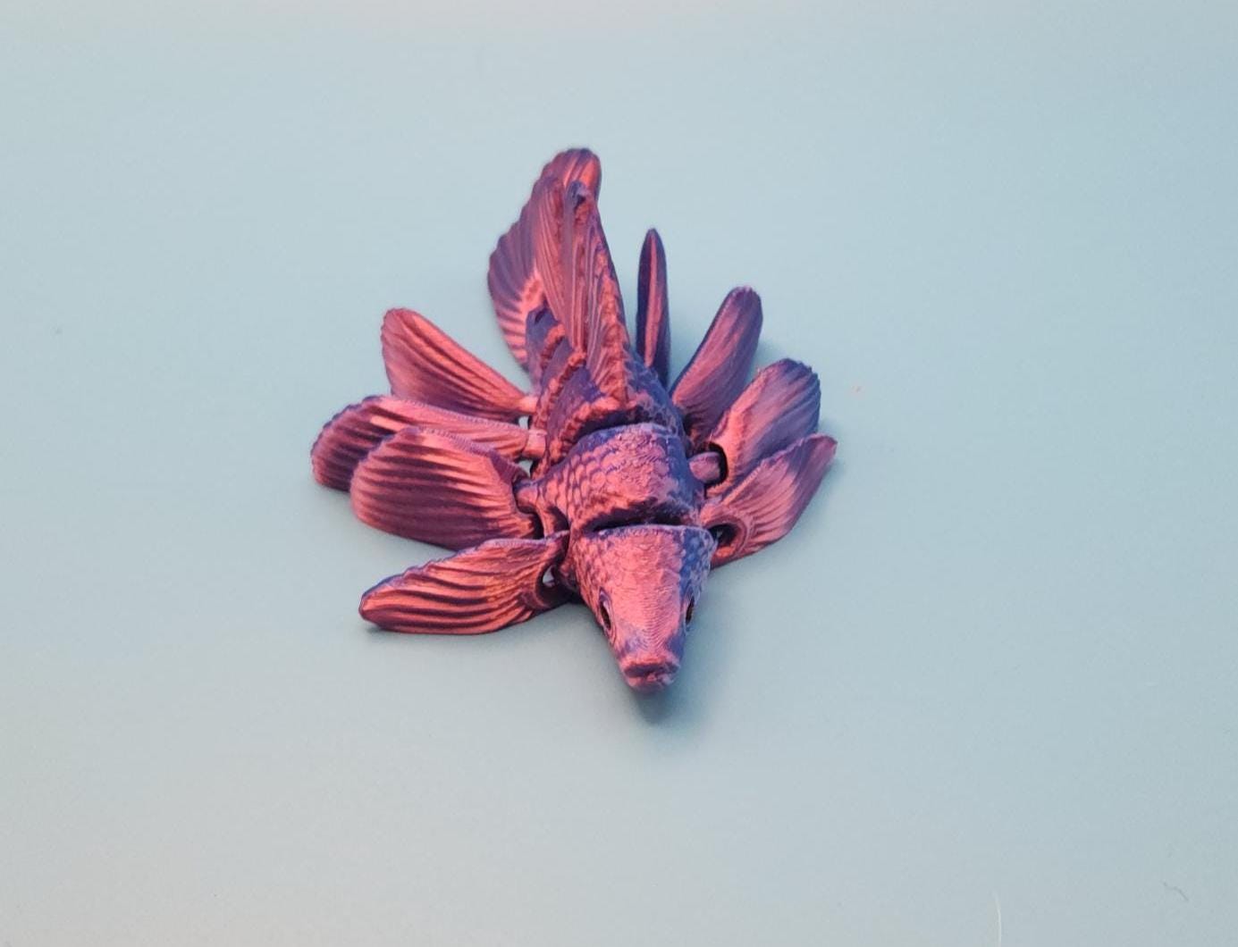 Purple 3D printed betta fish toy with detailed fins and textured body on a light background