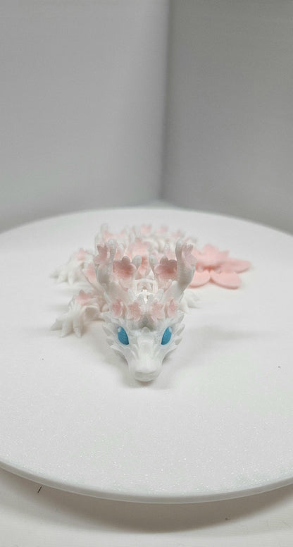 3D printed cherry blossom baby dragon figurine with blue eyes and delicate pink flower details