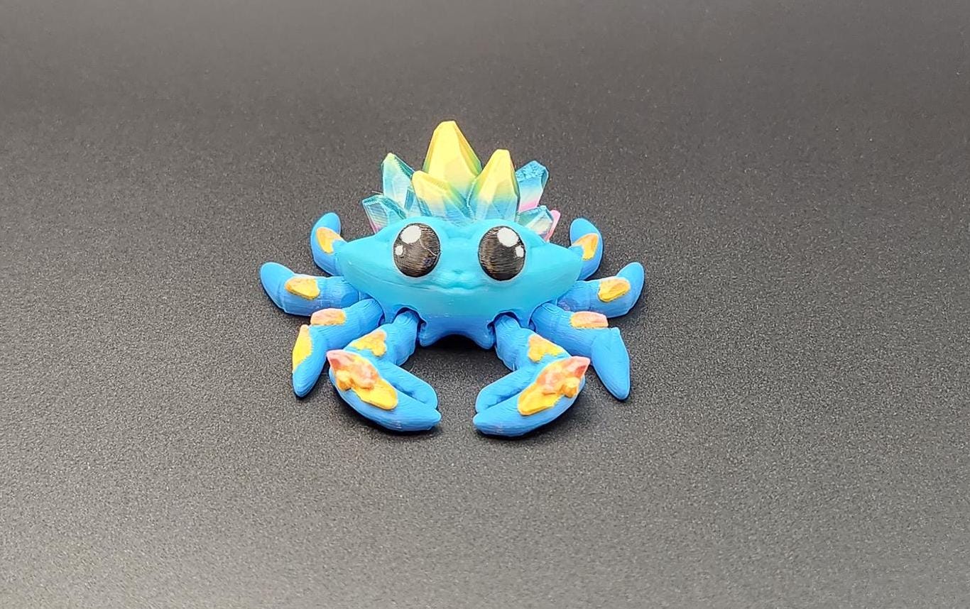 Colorful 3D printed crystal crab figurine with bright blue body and yellow crystal details