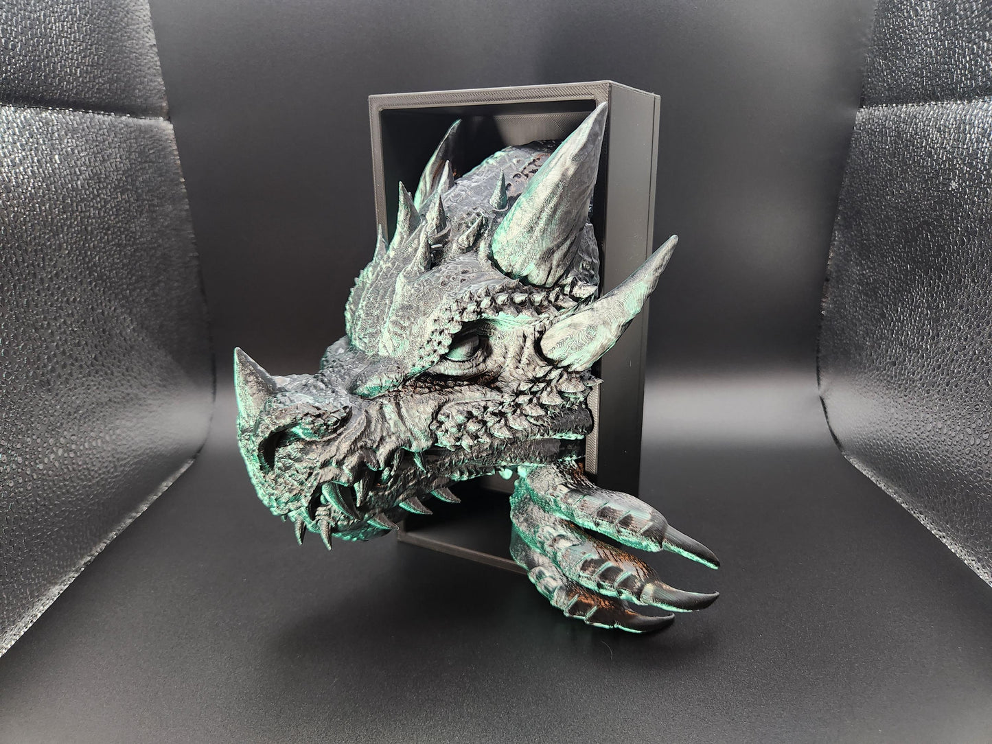 3D printed dragon bookend with detailed spikes and claws in black and green patina finish