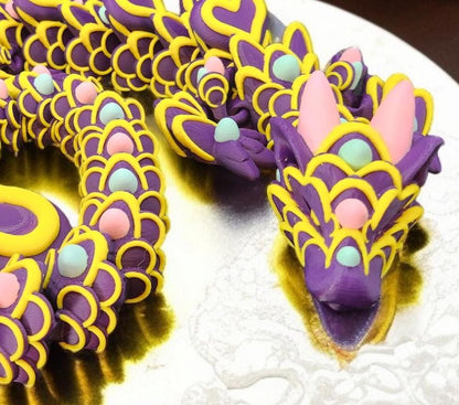 Colorful detailed 3D printed Easter dragon figurine in purple yellow and pastel pink on white background