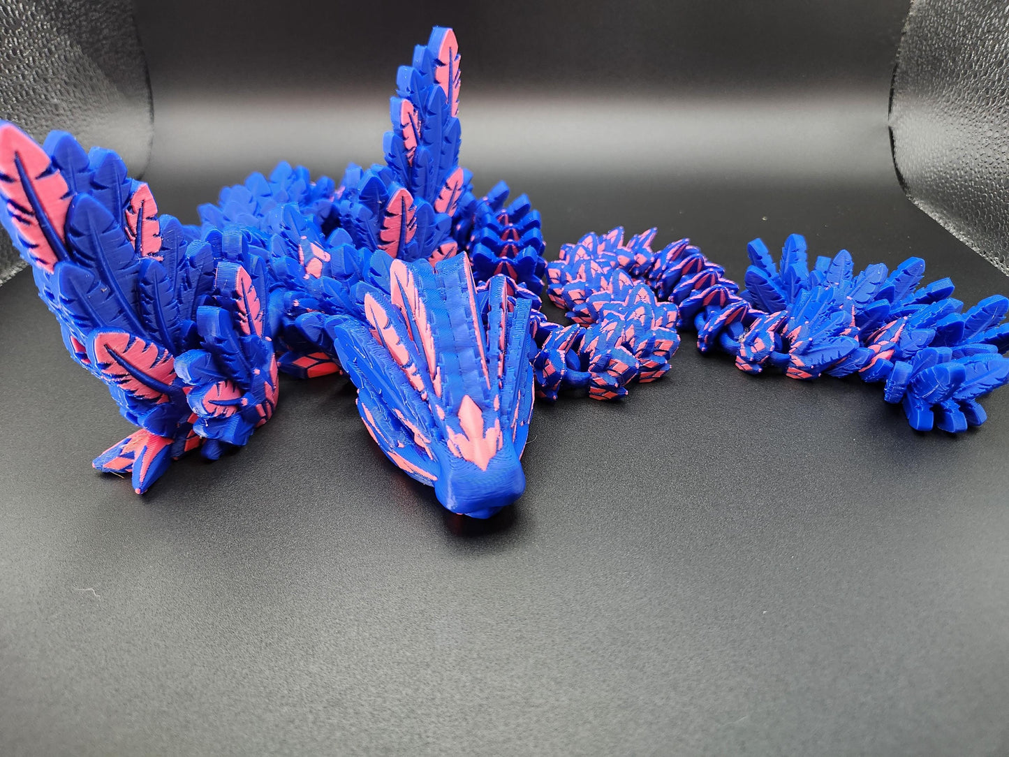 Blue and pink 3D printed feather dragon figurine showcasing intricate feather details and segmented body