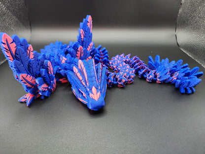 Blue and pink 3D printed feather dragon figurine with intricate feather details on black background