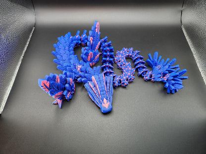Blue and pink 3D printed feather dragon figurine with detailed scales and wings on black background