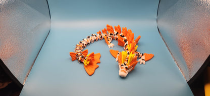 Colorful 3D printed koi dragon toy with intricate orange and white scales displayed on blue background