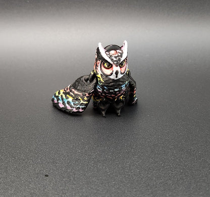 Colorful 3D printed owl keychain with detailed feathers and expressive eyes on black background