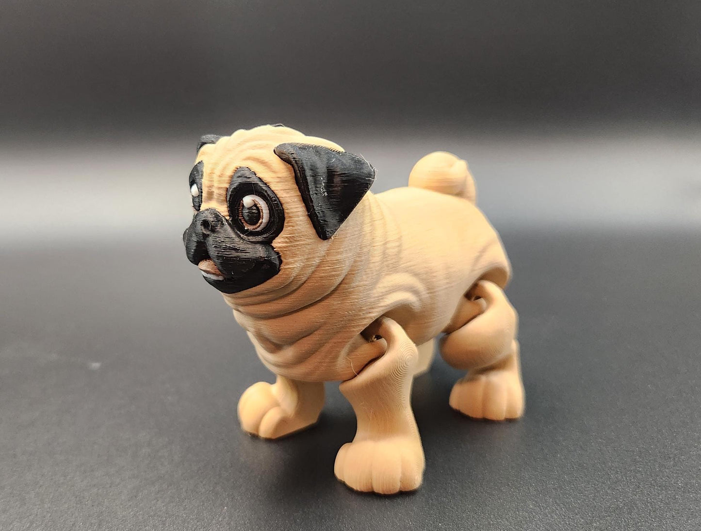Cute 3D printed pug toy with movable legs and detailed facial features in beige and black