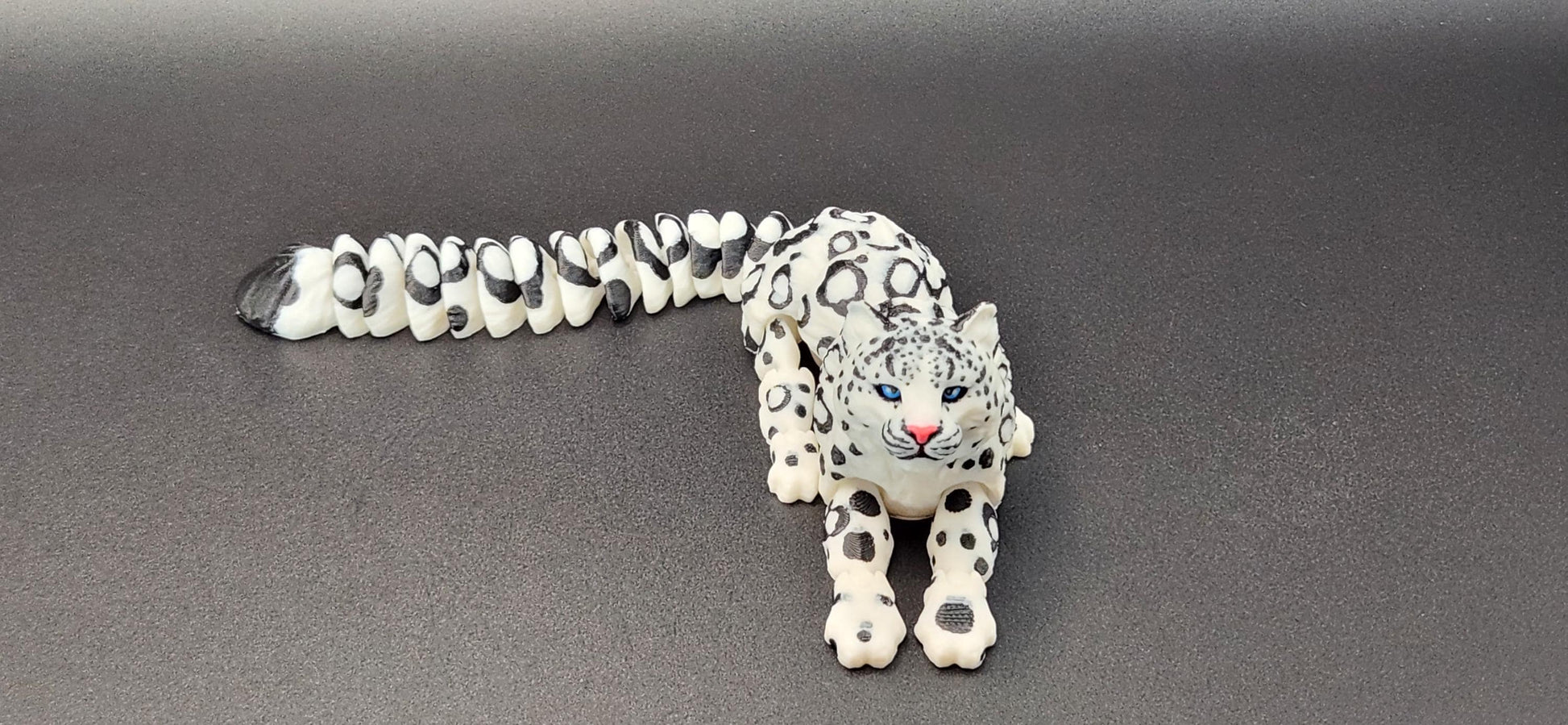 3D printed snow leopard figurine with intricate spotted design and detailed facial features