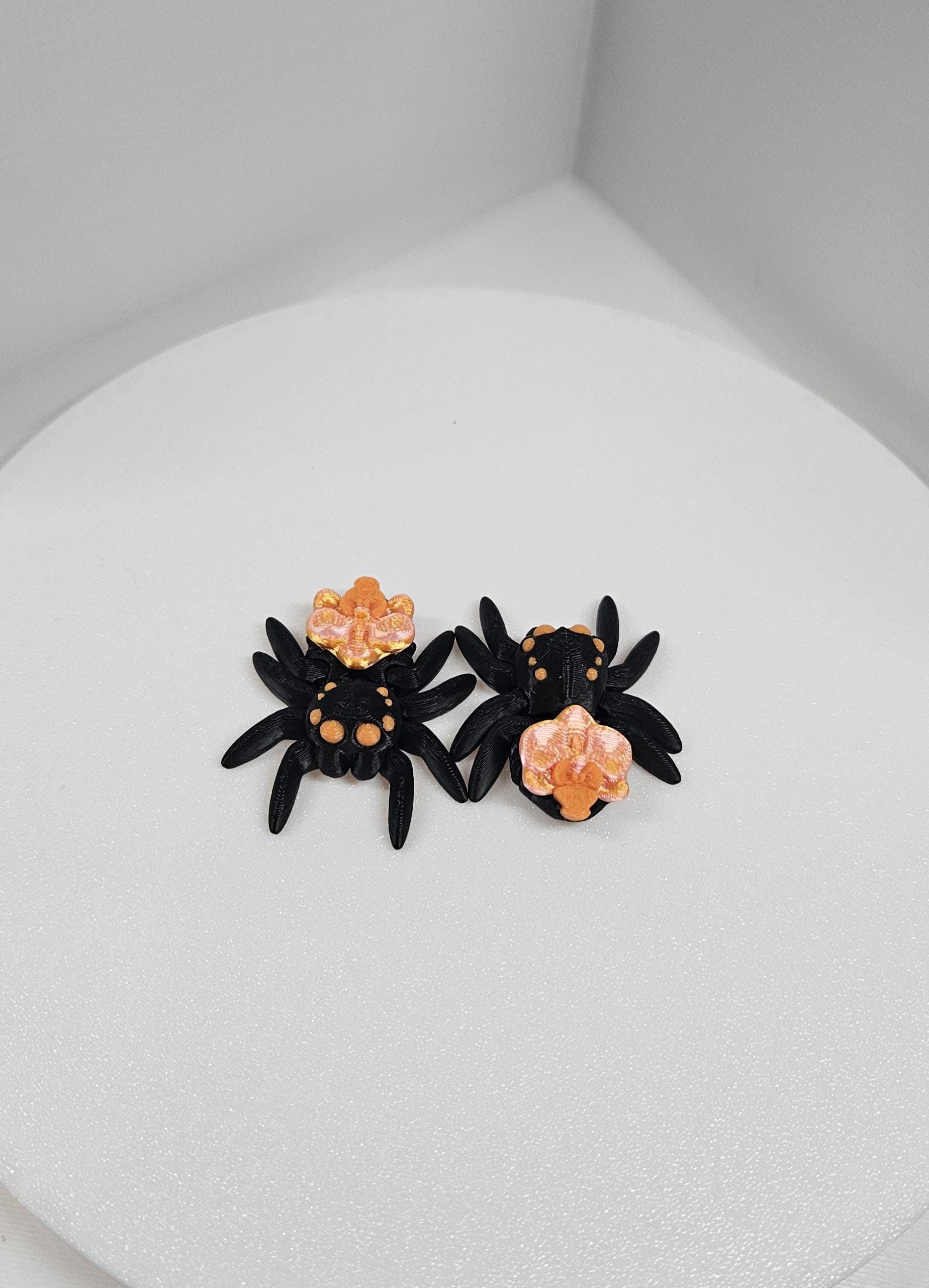 Black and orange 3D printed spider fidget toy with detailed legs and body texture on white background