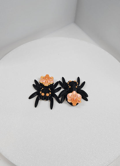 Black and orange 3D printed spider fidget toy with detailed legs and body texture on white background
