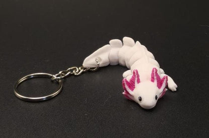 White and pink articulated axolotl keychain with movable segments attached to a metal ring