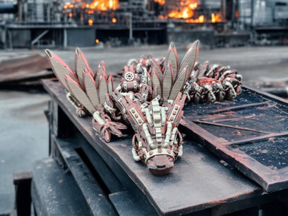 Articulated steampunk dragon figurine with mechanical wings and gears displayed on a metal surface