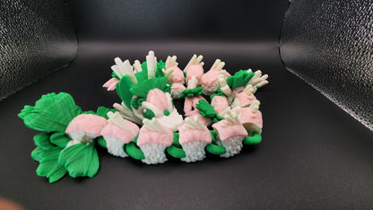 Articulated sushi dragon figurine made of green and pink sushi pieces with detailed tail and claws