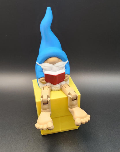 Book lover gnome ornament shelf buddy with blue hat reading a red book sitting on a yellow block