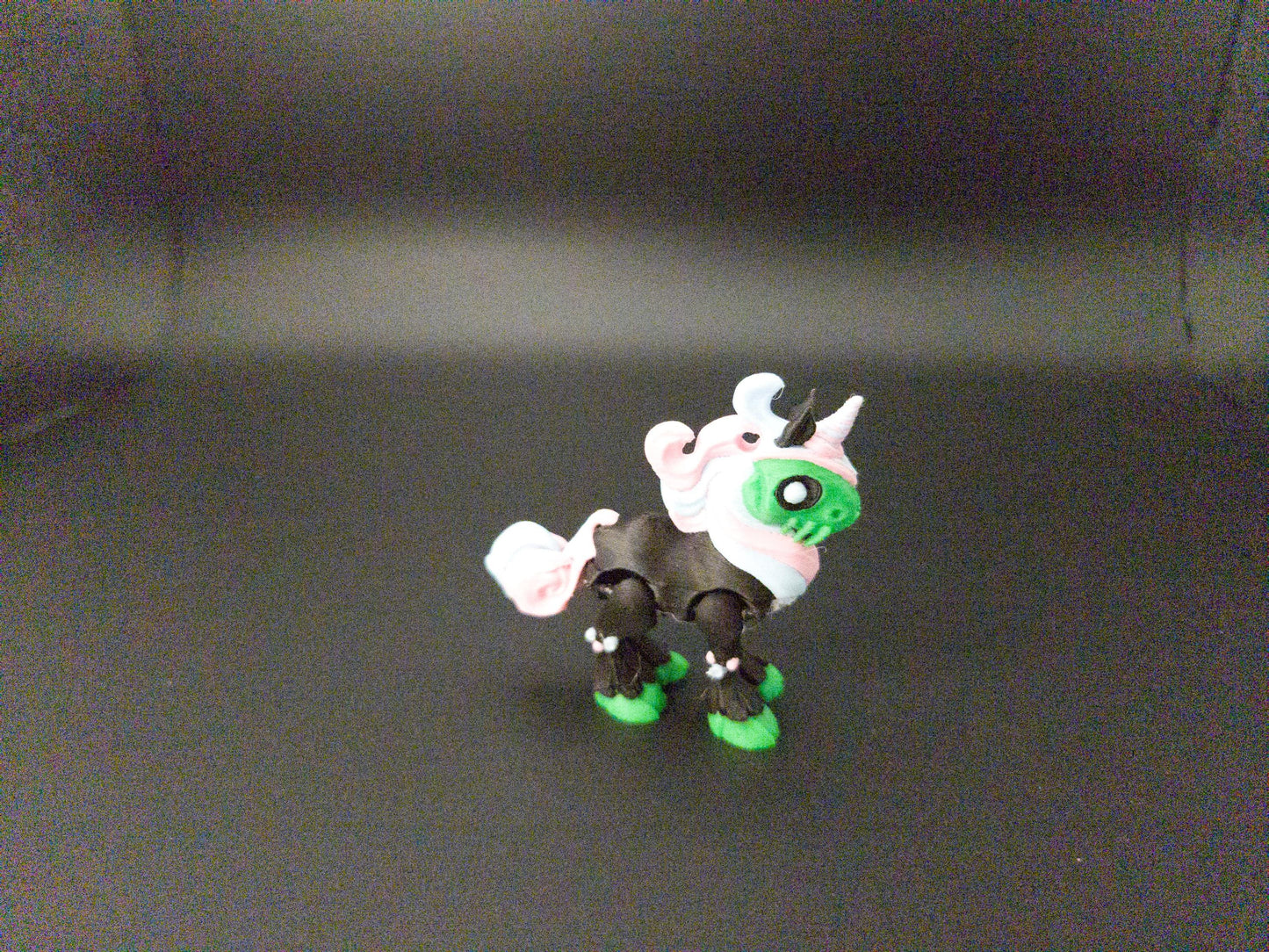 Crazy unicorn 3D print figurine in black, green, and white colors with a whimsical design
