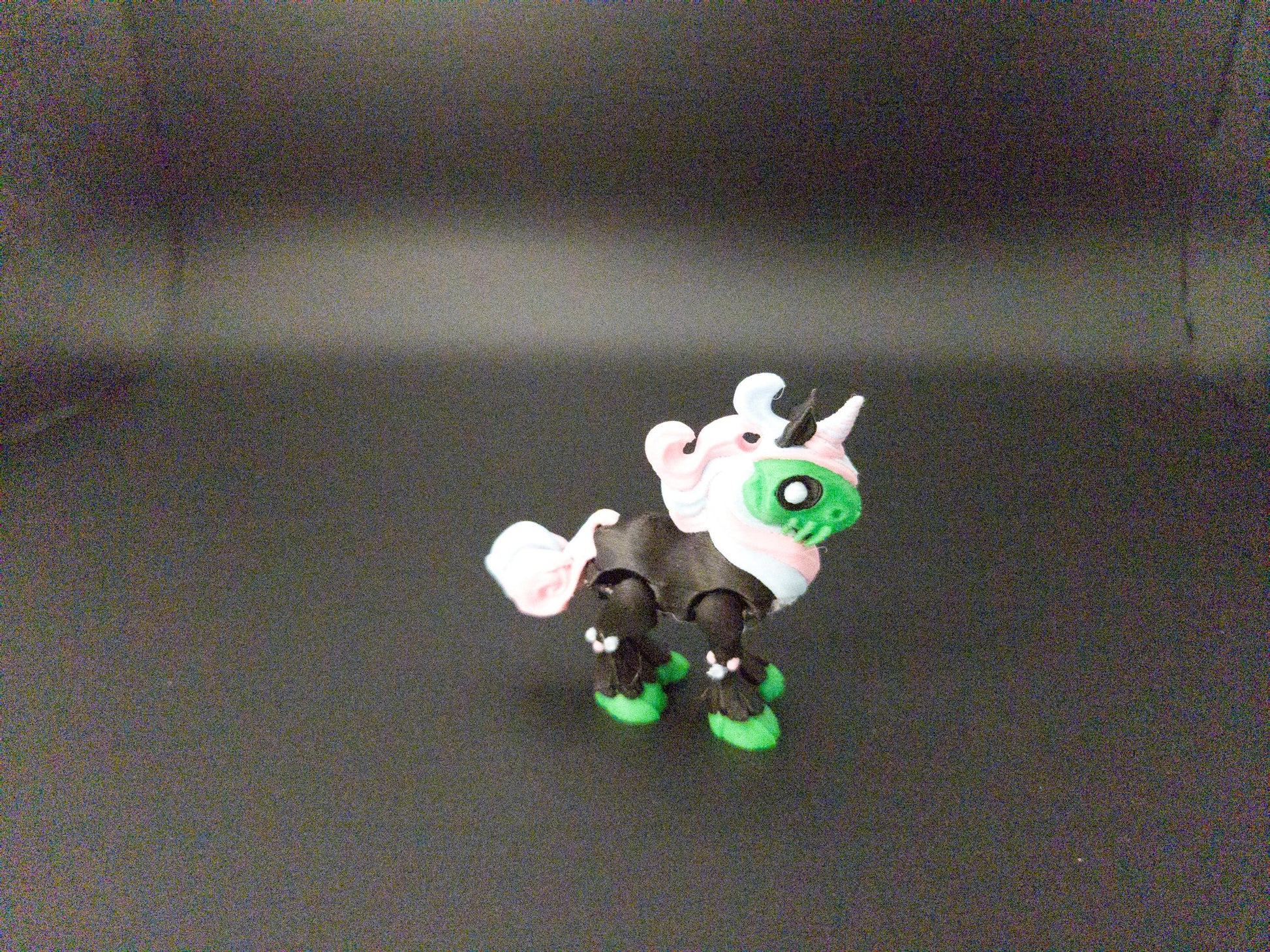 Crazy unicorn 3D print figurine in black, green, and white colors with a whimsical design