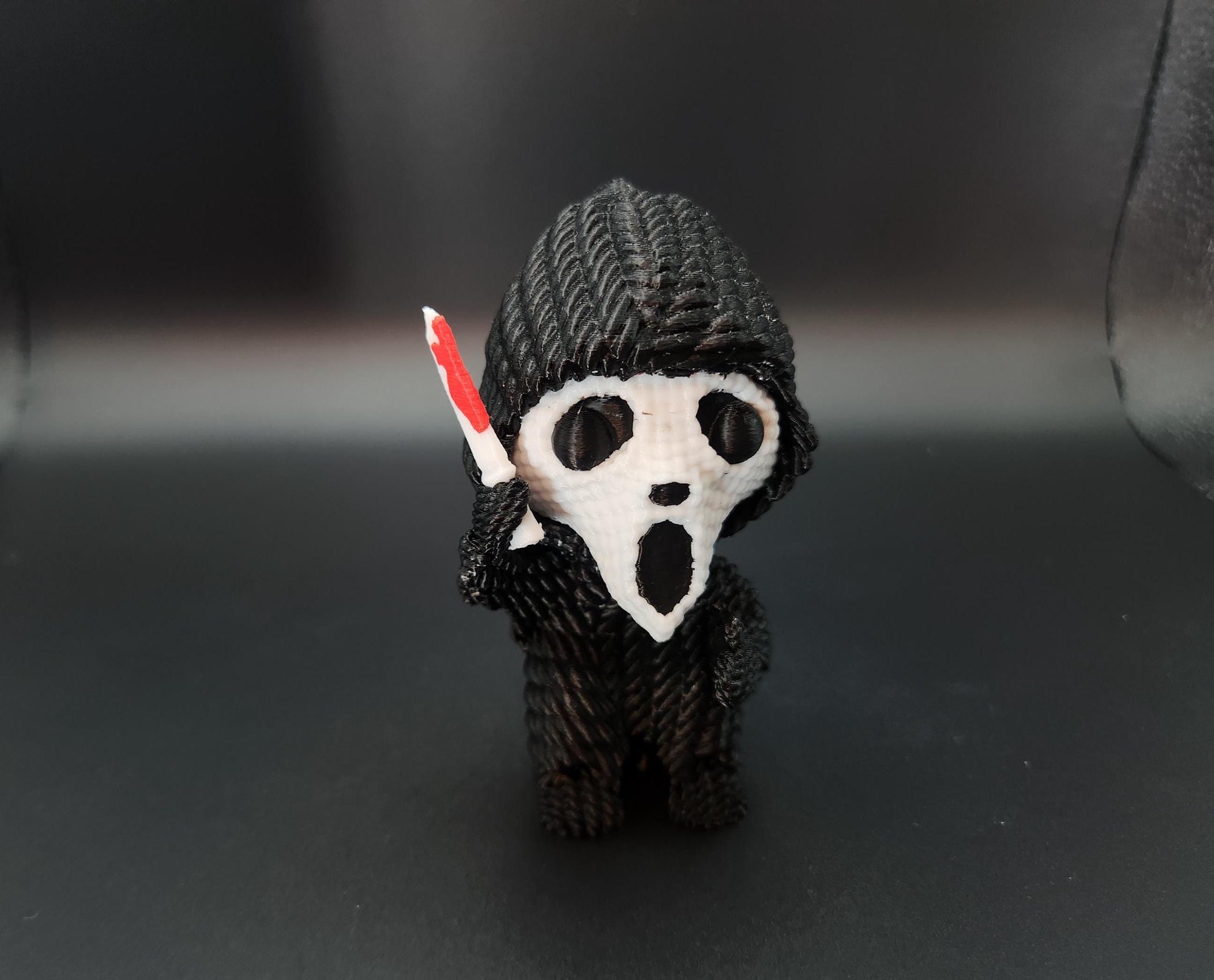 Handmade crochet texture scream gift figure with black hood and white mask holding a red knife