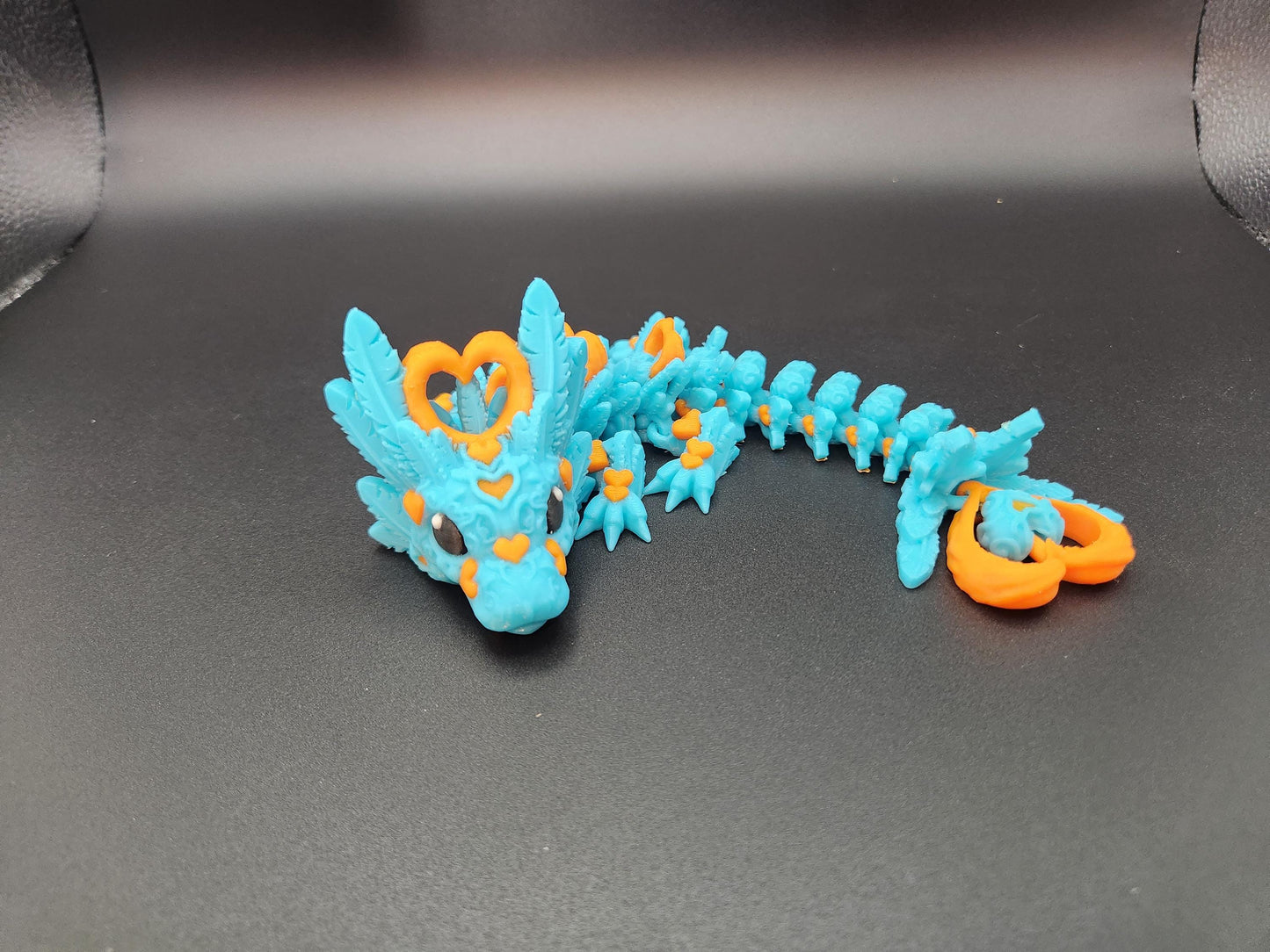 Cute flexy heart dragon figurine in blue with orange heart accents and detailed scales