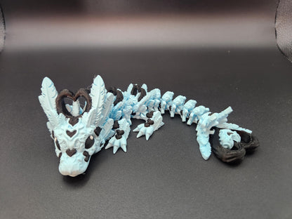 Cute flexy heart dragon figurine in blue and brown with heart details and flexible body on black background