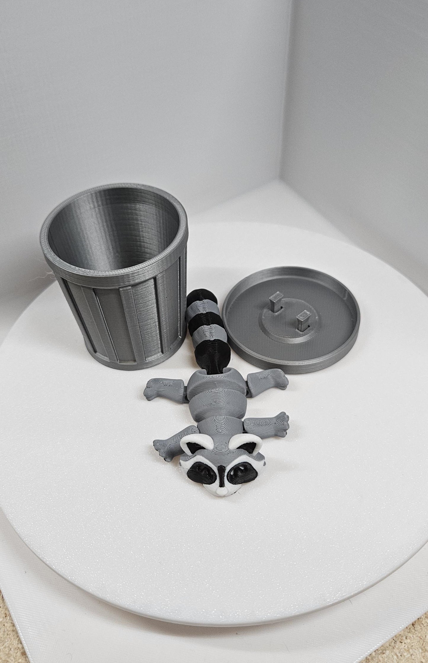 Articulated raccoon fidget figure with removable trash can and lid on white background