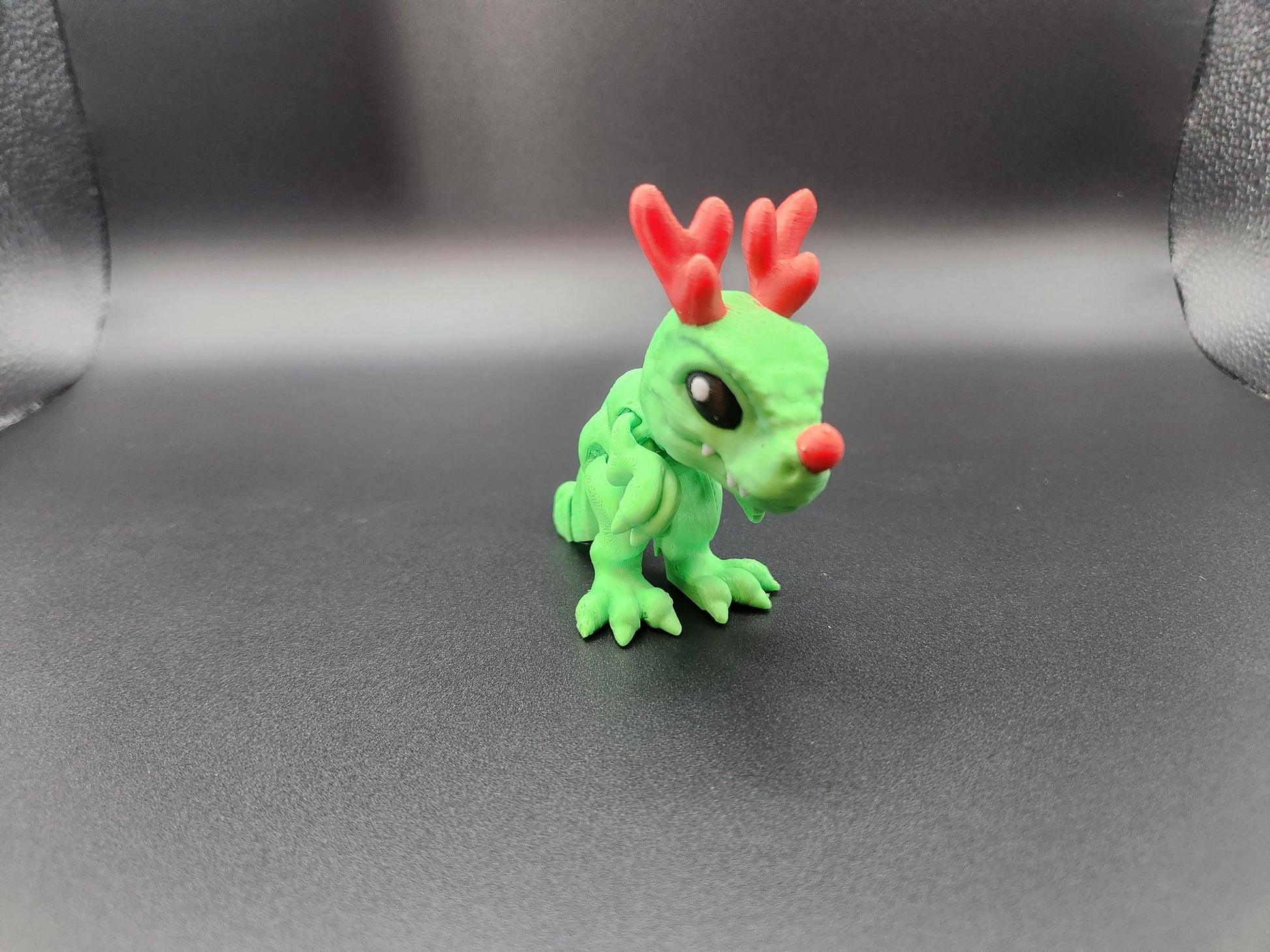 Etsy Christmas Santa T-Rex figurine in green with red antlers and nose on black background