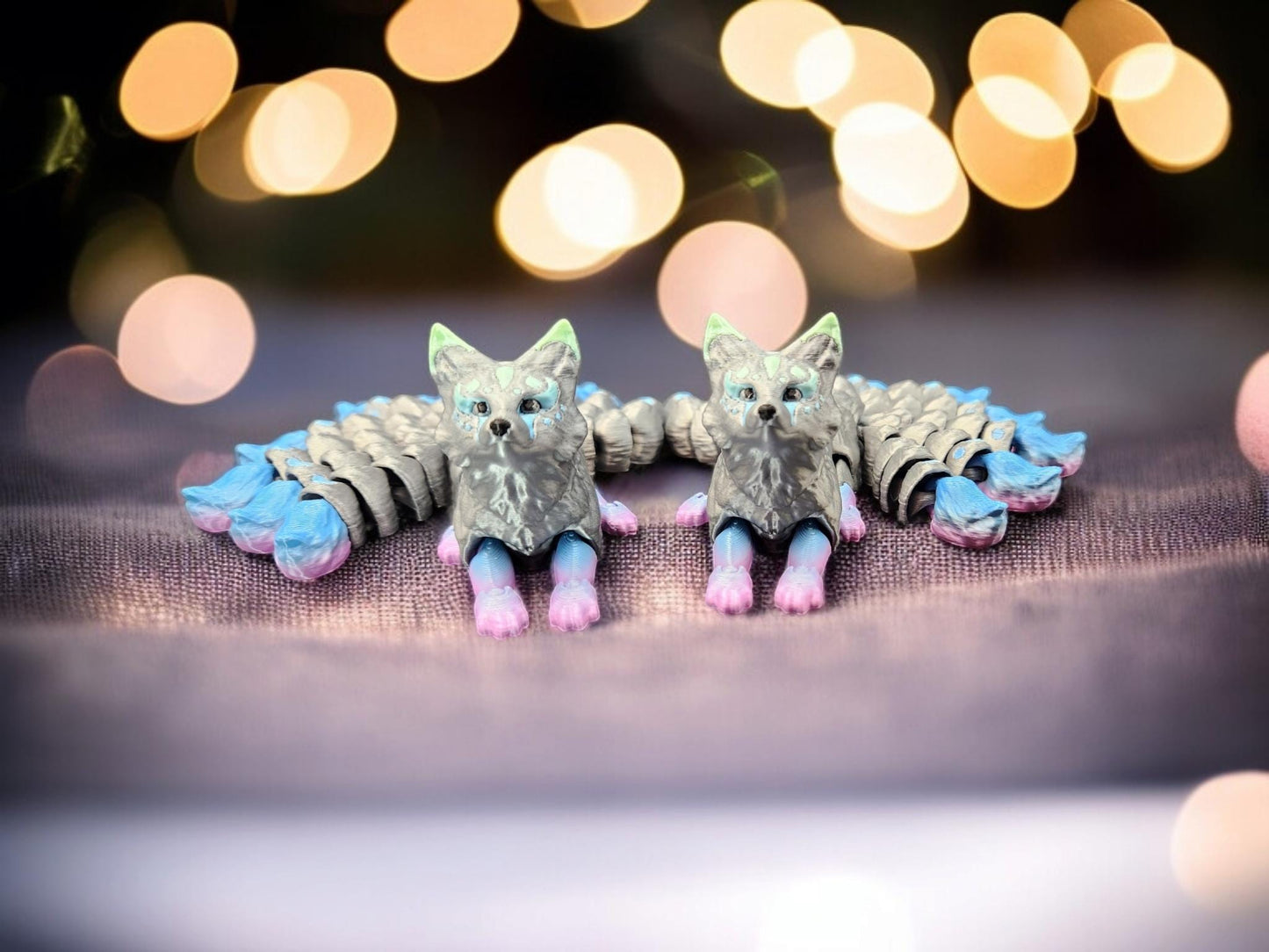 Pair of handcrafted Japanese kitsune figurine 9-tailed fox mythical creature in pastel blue and pink accents