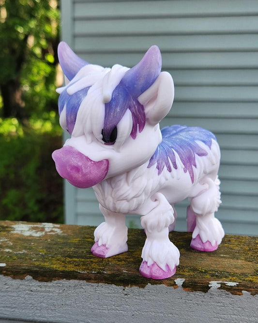 Purple and white Highland cow decor figurine with detailed fur and horns on wooden surface