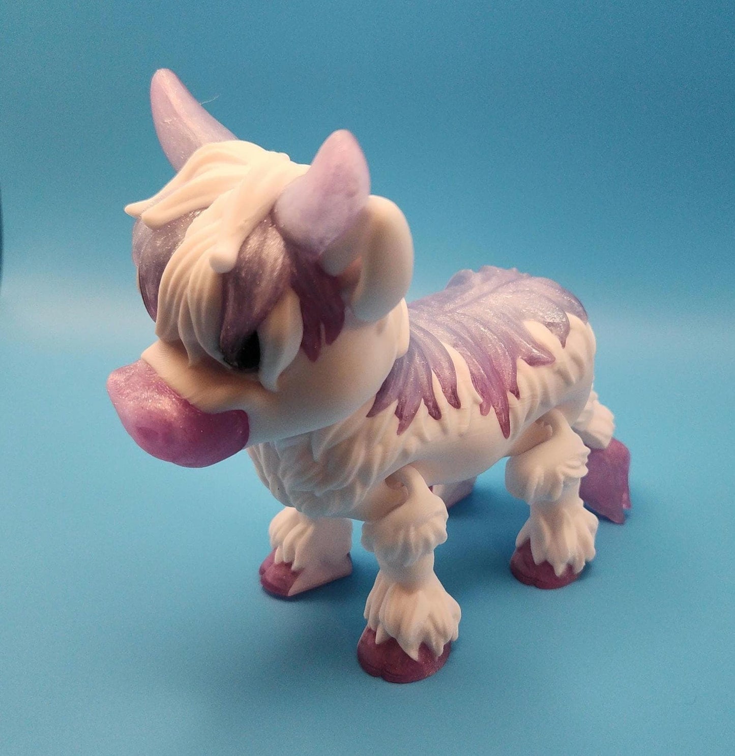 Purple and white Highland cow decor figurine with detailed fur standing on blue background
