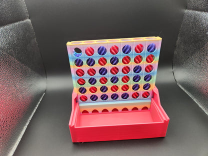 Colorful interactive 4-in-a-row game with red and purple tokens and a red base on black background