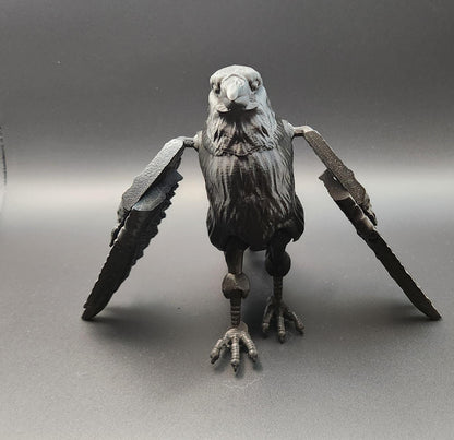 Black articulated raven figurine with detailed feathers and movable wings on gray background