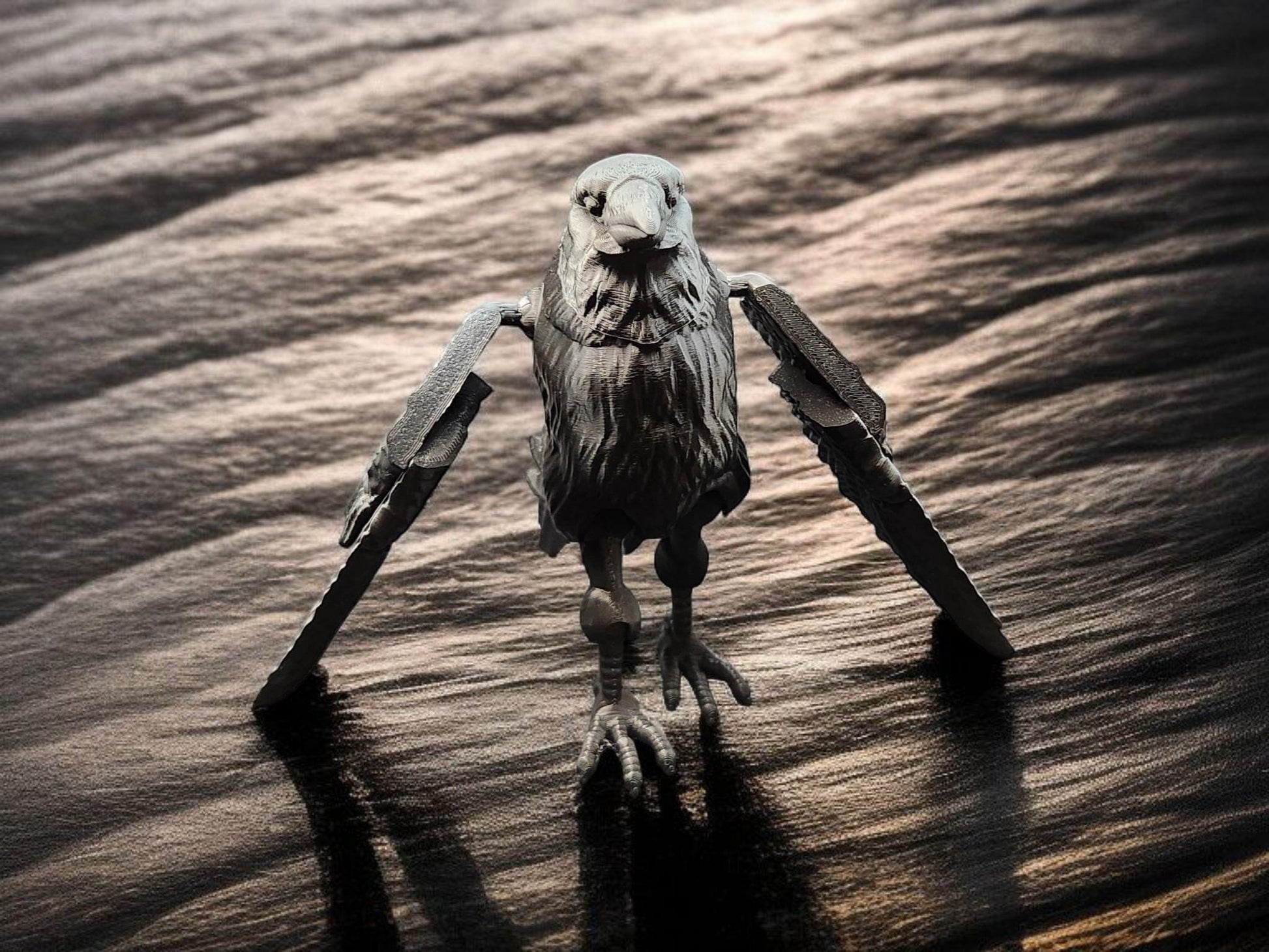 Black articulated raven figurine with movable wings standing on a textured dark surface