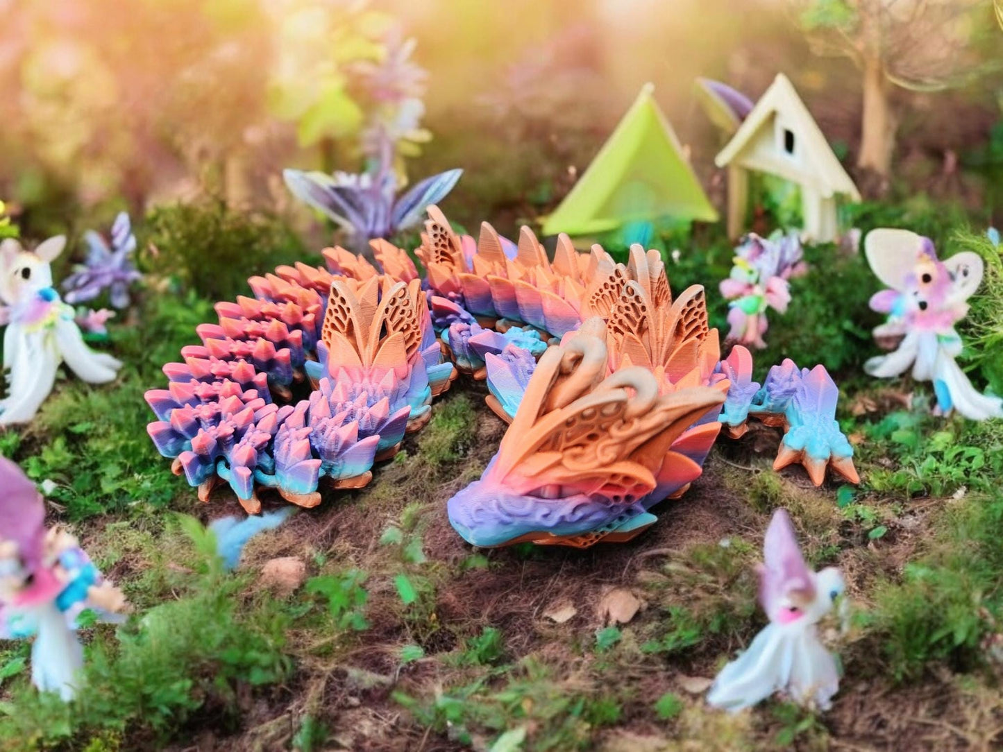 Multicolor fae dragon decor surrounded by miniature fairies and fantasy garden elements on mossy ground