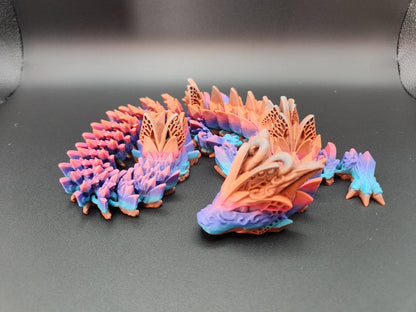 Multicolor fae dragon decor with intricate wing details in pink, purple, and blue on black background