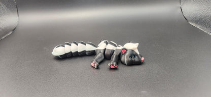 Realistic articulated Skunk Fidget toy in black and white with movable limbs on a gray background