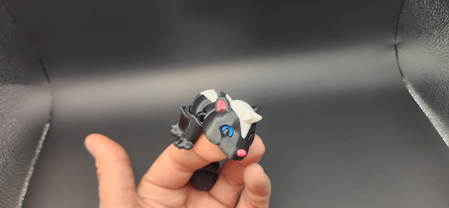 Hand holding a realistic articulated Skunk Fidget toy with detailed black and white design