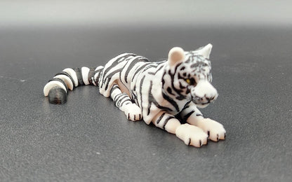 Realistic tiger figurine 3D print in black and white lying down on a dark surface