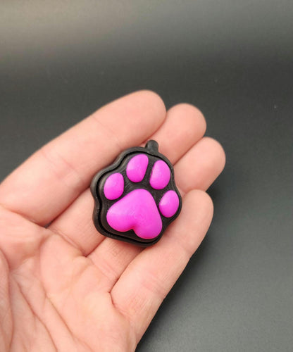  a black and pink paw-shaped sensory stress relief clicker for anxiety and focus