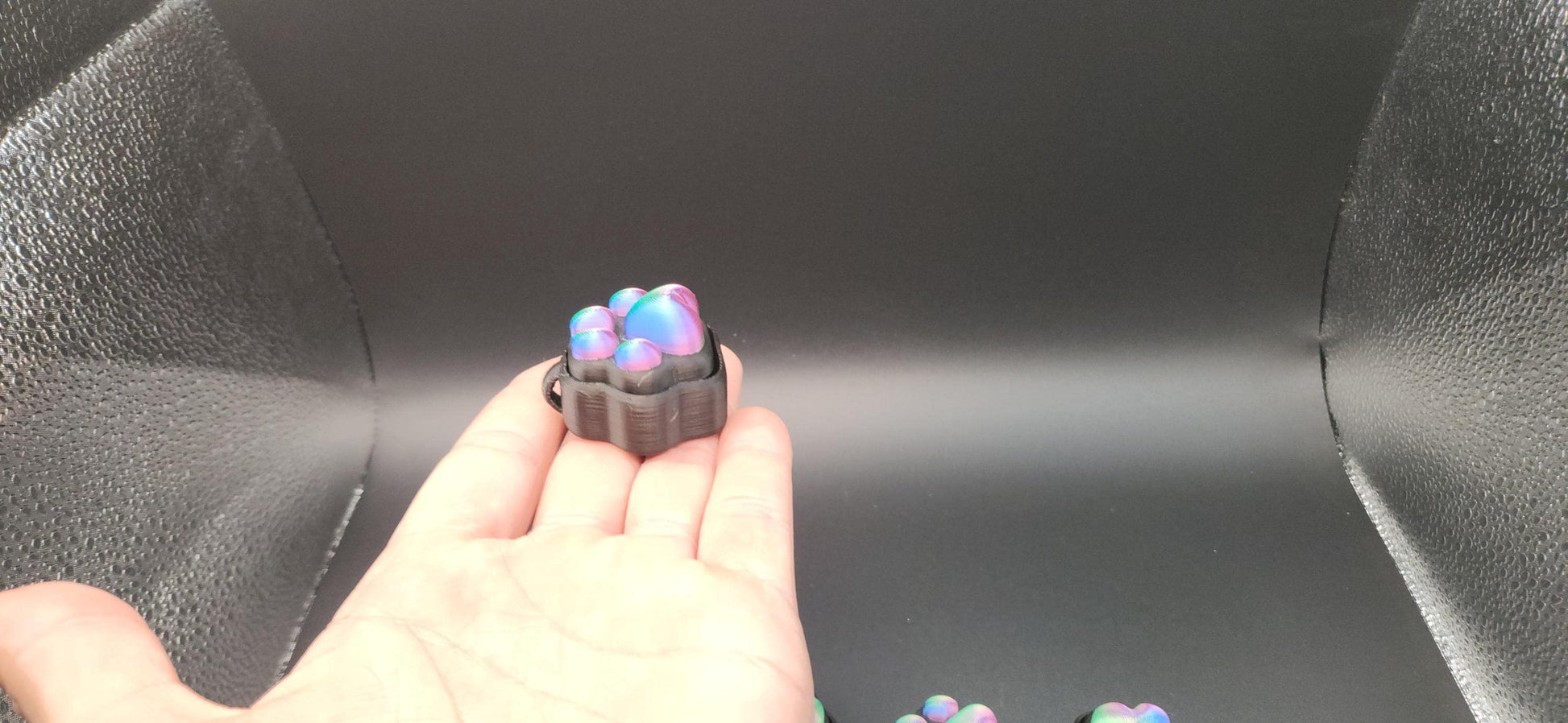  small sensory stress relief clicker with colorful silicone buttons on black background