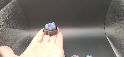  small sensory stress relief clicker with colorful silicone buttons on black background