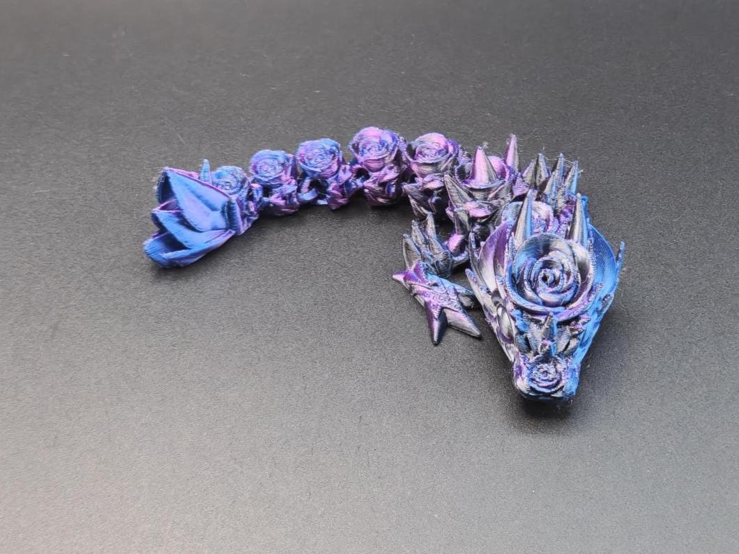 3D printed baby dragon figurine in purple and blue with detailed floral and spike design