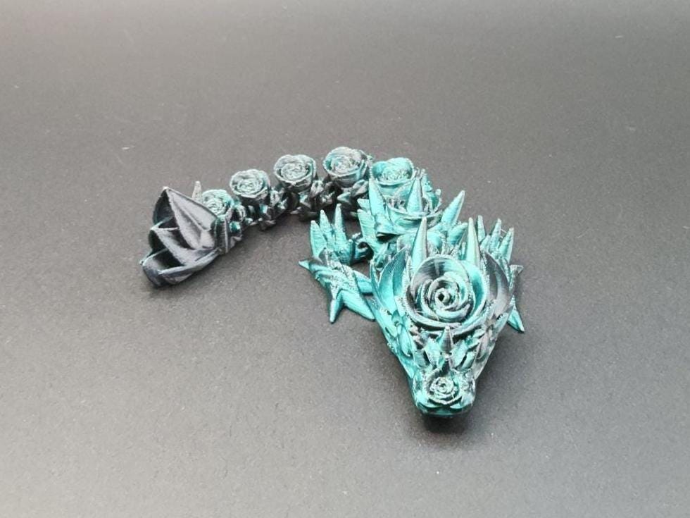3D printed baby dragon figurine with intricate floral and leaf designs in turquoise and black
