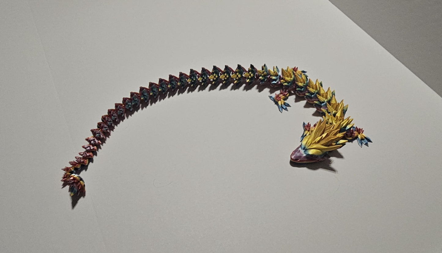 3D printed crystal dragon figurine with detailed multicolor scales and elongated body on a white background