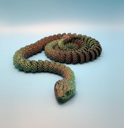 Realistic 3D printed rattlesnake toy with detailed scales and textured body on light blue background