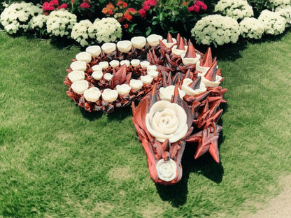3D printed rose dragon figurine with red and white floral design displayed on green grass