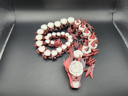 3D printed rose dragon figurine in red and white with detailed floral and spike design on black background