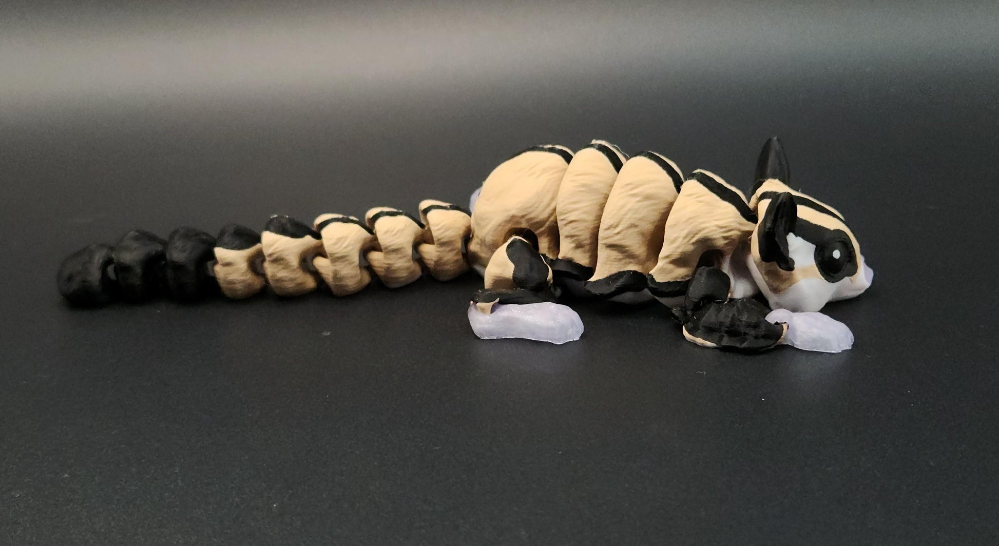 Hand-painted 3D printed sugar glider figurine with detailed black and cream coloring on black background